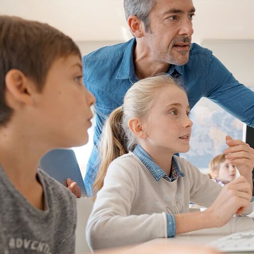 Lehrer mit Kindern am PC