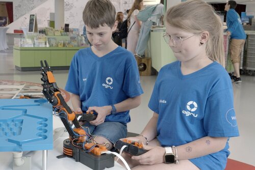 Kinder steuern im Rahmen der WIDI-Abschlussveranstaltung Roboterarme