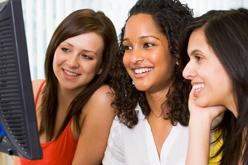 Drei Frauen sitzen vor dem Stand-PC